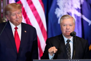 Former President Donald Trump listens as Sen. Lindsey Graham, R-S.C., speaks at a campaign event at the South Carolina Statehouse, Jan. 28, 2023, in Columbia, S.C. (AP Photo/Alex Brandon, File)
