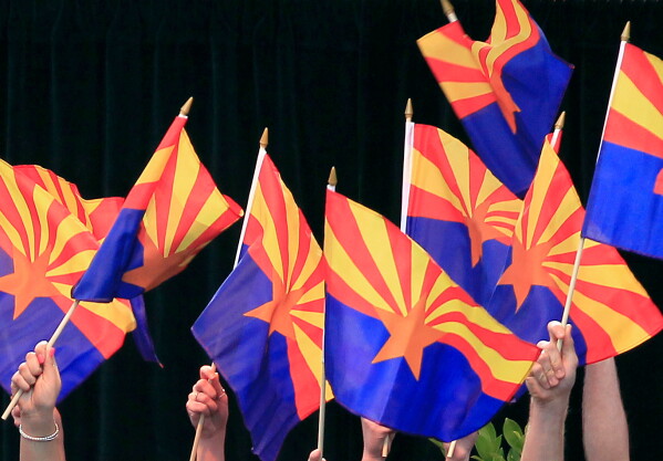 Members of the Arizona State University Barrett Choir wave Arizona state flags during the celebration of the 100th anniversary of Arizona's statehood, Feb. 14, 2012, in Phoenix.(AP Photo/Ross D. Franklin, File)
