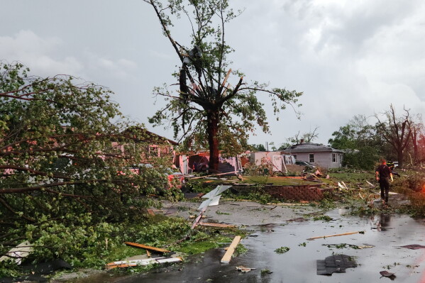 First responders walk through debris on Thursday, June 11, 2026 after a tornado passed through Merrillville, Ind. (Michael Sneiderwine via AP)