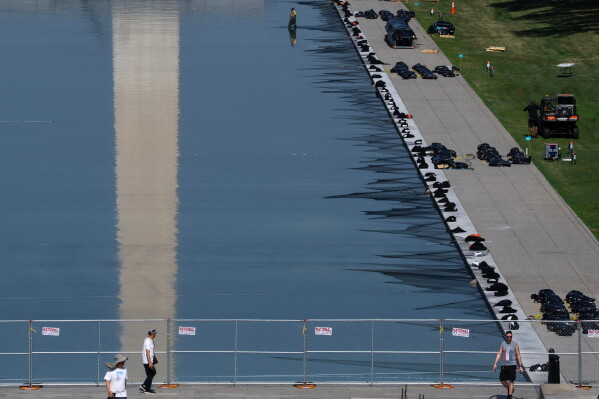 Workers install fireworks along the edge of the Lincoln Memorial Reflecting Pool ahead of the America 250 July 4th celebration on the National Mall, Thursday, July 2, 2026, in Washington. (AP Photo/Nathan Howard)