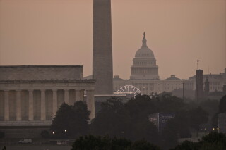 The Lincoln Memorial, the Washington Monument, and the U.S. Capitol, are seen at dawn from an overlook in Arlington, Va., as Washington prepares for sweltering temperatures, Friday, July 3, 2026. (AP Photo/J. Scott Applewhite)
