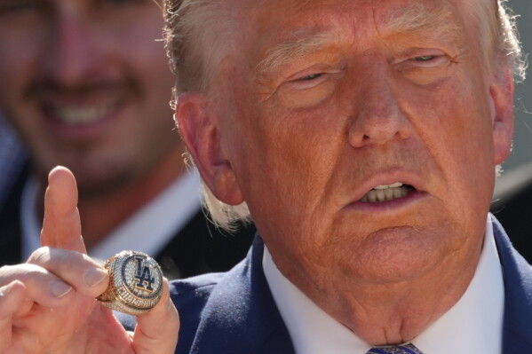 President Donald Trump holds a championship ring during an event to honor the 2025 World Series champions Los Angeles Dodgers in the Rose Garden of the White House, Thursday, July 23, 2026, in Washington. (AP Photo/Alex Brandon)