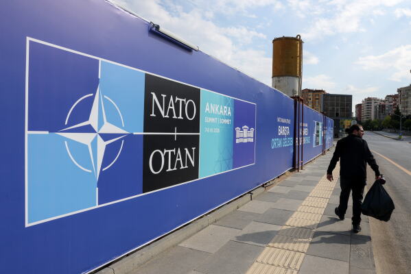 A man walks past a banner ahead of the NATO Summit in Ankara, Turkey, Sunday, July 5, 2026. (AP Photo/Riza Ozel)
