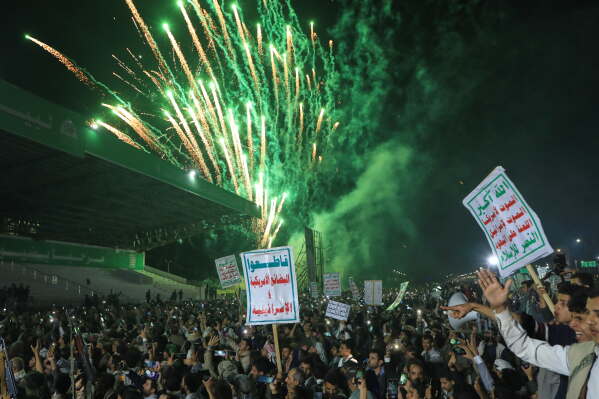 Fireworks burst as Houthi supporters rally against the Saudi-led coalition in Sanaa, Yemen, Monday, July 20, 2026. Placards in Arabic read: "God is great, Death to America, Death to Israel, A curse on the Jews and Victory to Islam" and "boycott American and Israeli goods". (AP Photo/Osamah Abdulrahman)